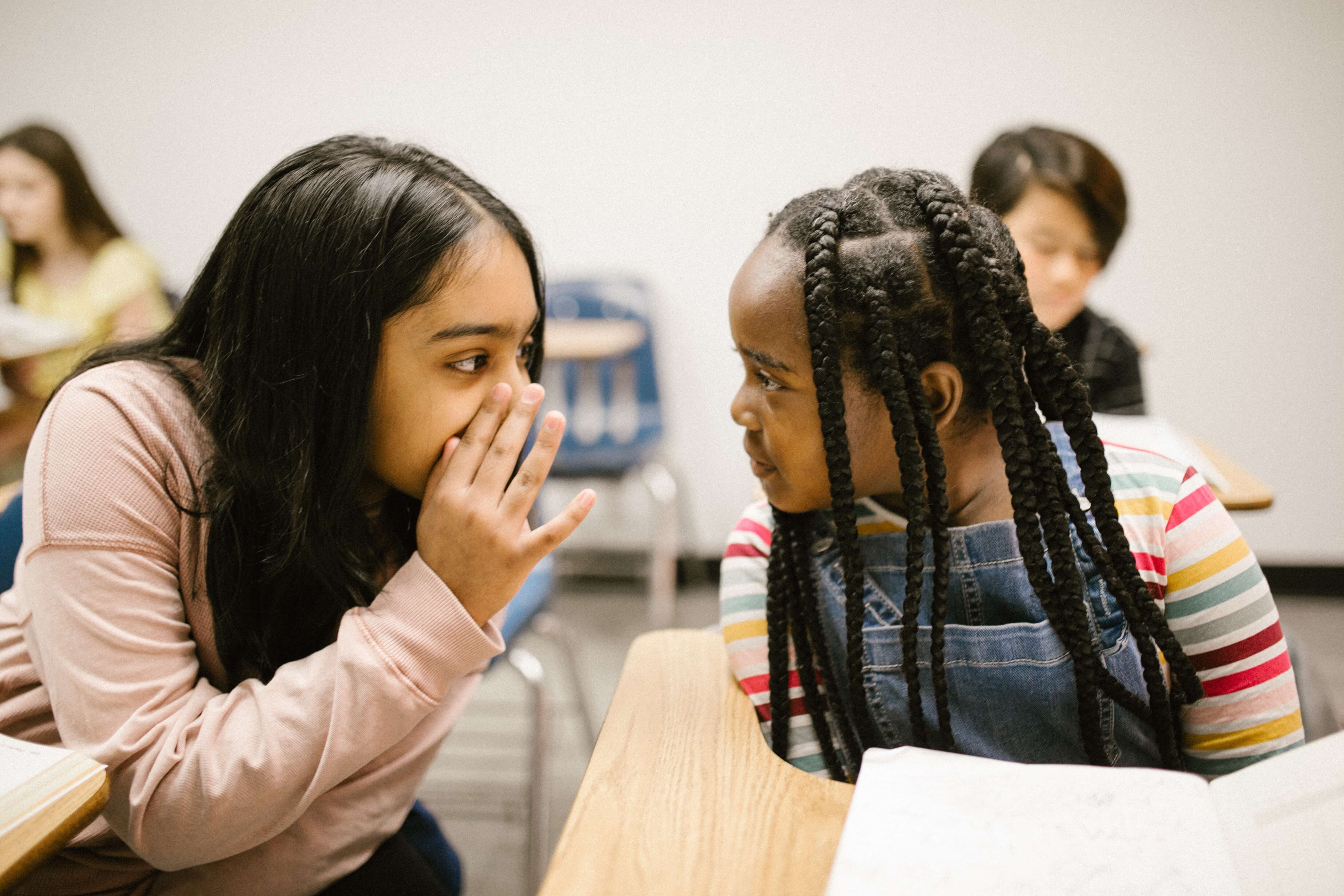 A girl gossips to another girl